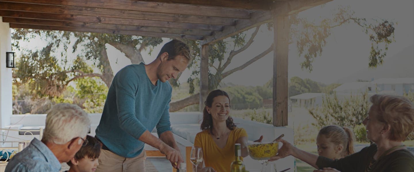 Three generations enjoying lunch together on an open outdoor patio.